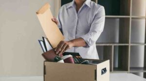 woman with office items packed in box. learn how to quit a job gracefully