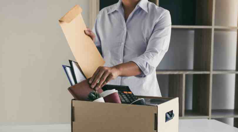 woman with office items packed in box. learn how to quit a job gracefully